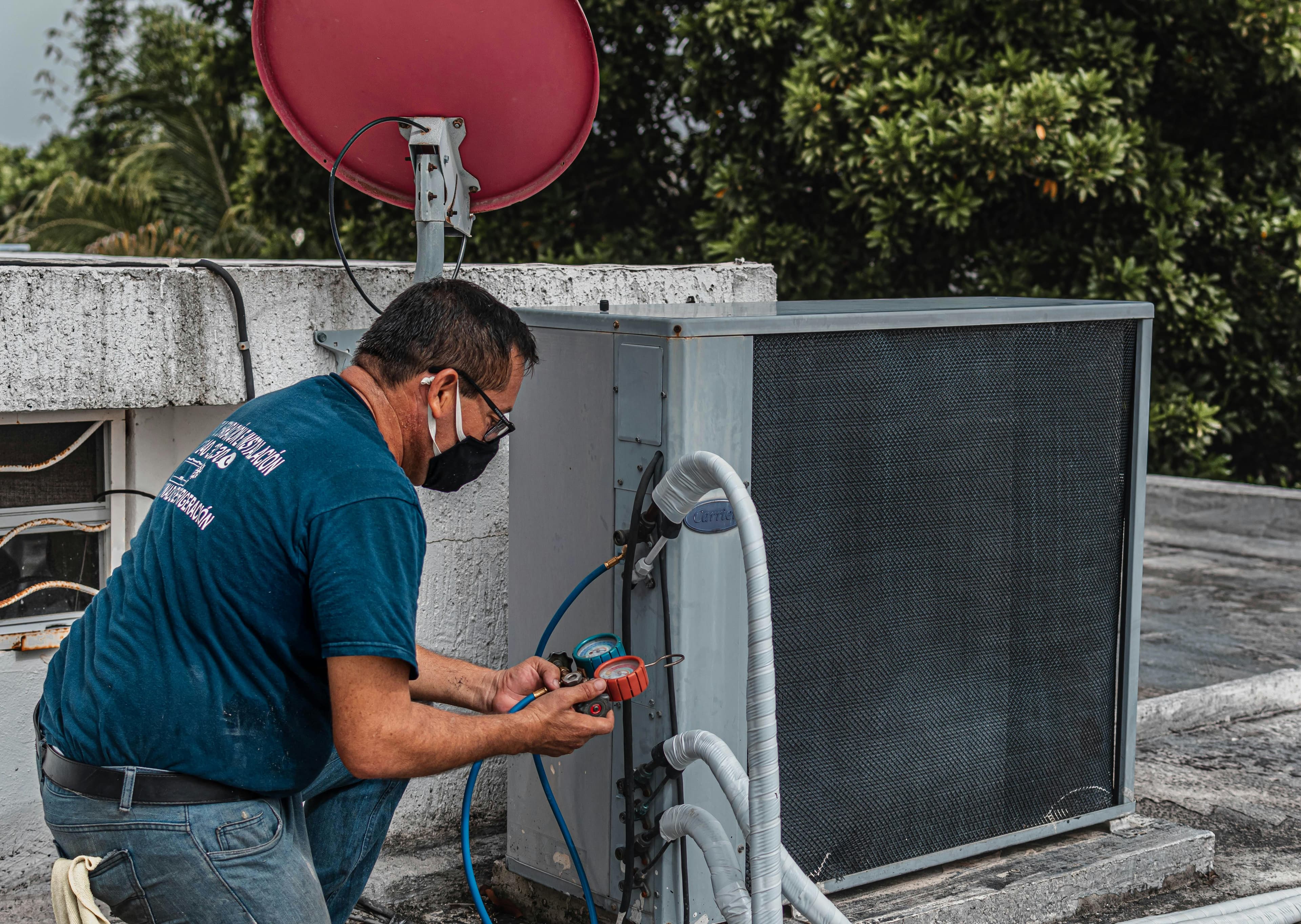 HVAC technician working on an outdoor unit